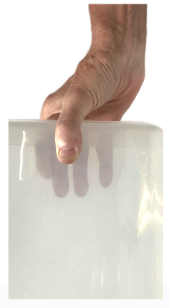 holding a small box at the side of the body from above.